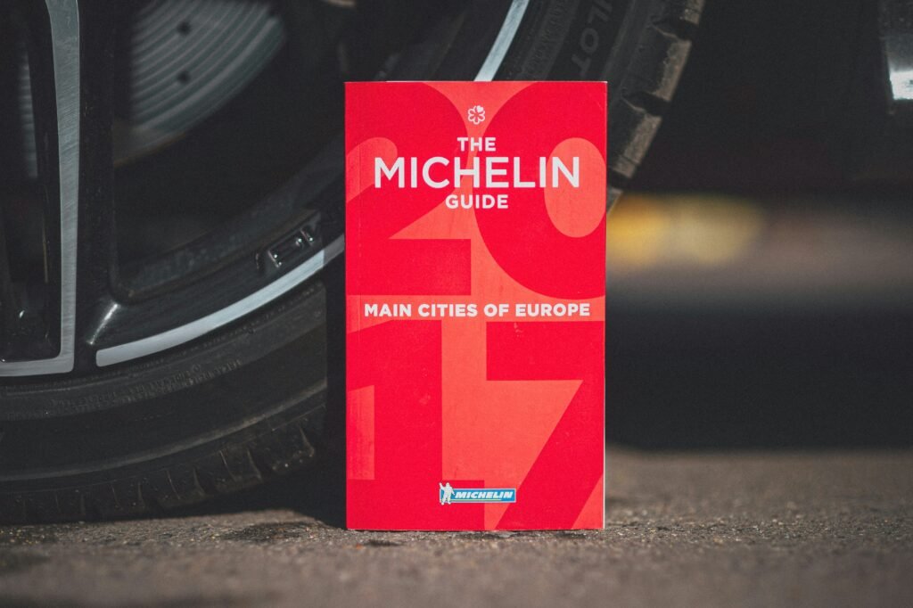 a red book sitting on the ground next to a tire